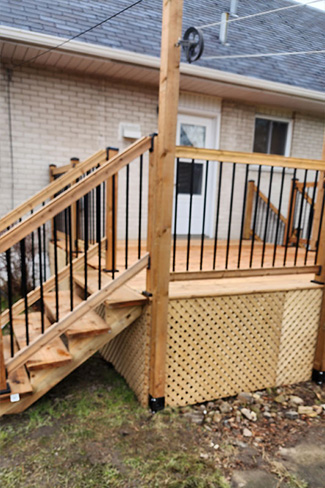 Construction d'un petit patio en bois traité avec un poteau de corde à linge